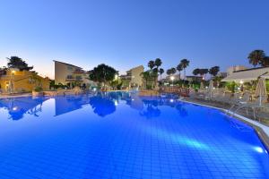 a large swimming pool at a resort at night at Makronisos Village in Ayia Napa