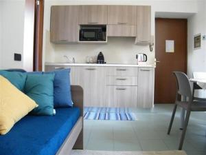 a living room with a couch and a kitchen at Residenza acqua terra fuoco in Como