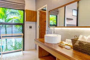 a bathroom with a sink and a mirror at Ao Luek Panoramic Pool-SHA Plus in Ao Luk