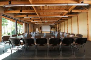 una gran sala de conferencias con una mesa larga y sillas en Reinis, en Turaida