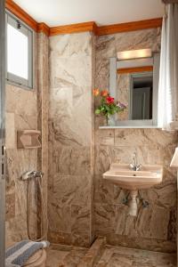 a bathroom with a sink and a mirror and a shower at Vlachakis Hotel in Stalís