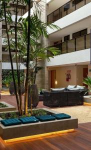 un edificio con cortile, palme e panchine di Flat Eco Summer Tambaú Apto 2Qts, Cozinha completa a João Pessoa
