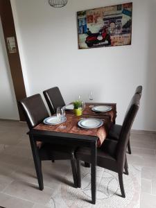 - une table en bois avec deux chaises et une table avec des assiettes dans l'établissement La Naval 209, 5ºA - LONDRES -, à Las Palmas de Gran Canaria