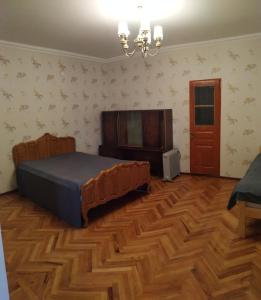 um quarto com uma cama e piso em madeira em Hope Lake city Apartment em Zaqatala