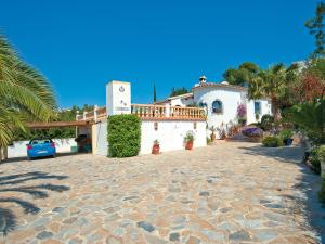 une grande maison blanche avec une voiture garée dans une allée. dans l'établissement Holiday Home Mirada al Sol by Interhome, à Moraira