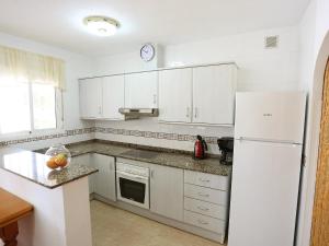 a kitchen with white cabinets and a white refrigerator at Holiday Home Vicky by Interhome in Riumar