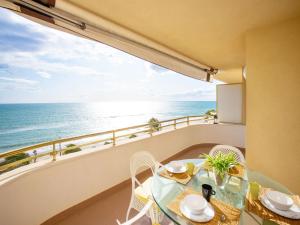 balcón con mesa, sillas y vistas al océano en Apartment Front Beach by Interhome en Calafell