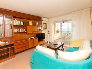 sala de estar con sofá azul y TV en Apartment Front Beach by Interhome, en Calafell