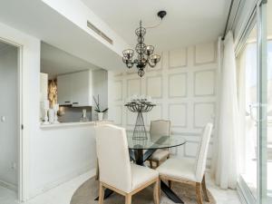 jadalnia ze szklanym stołem i białymi krzesłami w obiekcie Apartment Arenal-2 by Interhome w mieście Jávea