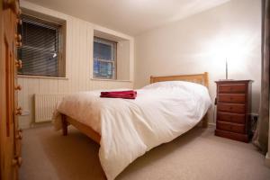 a bedroom with a bed with a red shirt on it at Bank Street Gallery in Kirriemuir