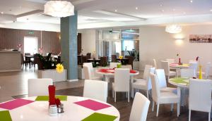 a dining room with tables and white chairs and tablesktop at Zajazd u Marcela in Goleniów