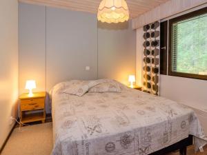 1 dormitorio con 1 cama con 2 mesitas de noche y 2 lámparas en Holiday Home Lomaranta by Interhome, en Ruvaslahti