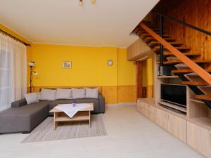 a living room with a couch and a tv at Holiday Home Hibiscus by Interhome in Balatonkeresztúr +11 photos