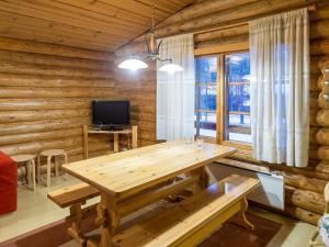 a wooden dining room with a table and a television at Holiday Home Honkakeko by Interhome in Sirkka