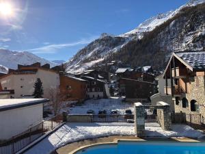 ein Resort in den Bergen mit Pool im Schnee in der Unterkunft Studio Chalets de Solaise in Val dʼIsère