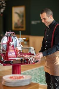 a man standing in front of a food machine at Mercure Rambouillet Relays Du Château in Rambouillet