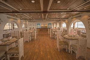 a restaurant with white tables and chairs and wooden ceilings at SUNRISE Mahrousa Cruise in Luxor