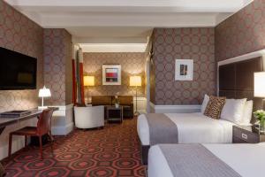 um quarto de hotel com duas camas e uma secretária em Empire Hotel em Nova Iorque