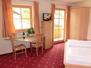 a bedroom with a table and chairs and a bed at Trinnerhof in Natz-Schabs