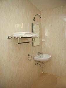 a bathroom with a sink and a mirror at Troppo Zone Puri Rama Resort Kuta in Legian