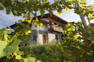 een huis met een balkon erbovenop bij Pri Marjotu in Kojsko