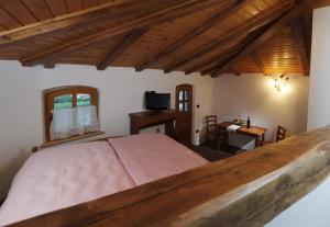 a bedroom with a large bed and a desk at Pri Marjotu in Kojsko