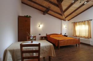 ein Schlafzimmer mit einem Bett und einem Tisch mit einem Stuhl in der Unterkunft Pri Marjotu in Kojsko