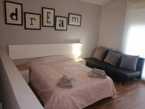 um quarto com uma cama e um sofá e fotografias na parede em Casa de la huerta em Múrcia