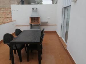 a table and chairs in a room with a stove at Casa de la huerta in Murcia