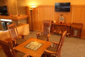 a dining room with a table and chairs and a television at Ramada by Wyndham Alpena in Alpena