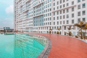 a swimming pool in front of tall buildings at SUPER OYO Collection O 24 Patraland Urbano in Bekasi