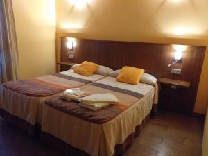 una habitación de hotel con una cama grande con almohadas amarillas en OTXOENEA, en Irún