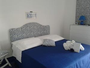 a bedroom with a bed with a blue blanket and a dresser at Casa Blu Cobalto in Maiori