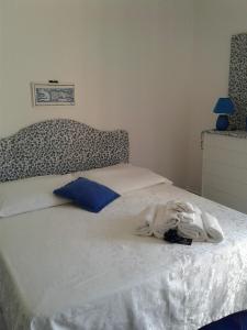 a bed with white sheets and blue pillows on it at Casa Blu Cobalto in Maiori