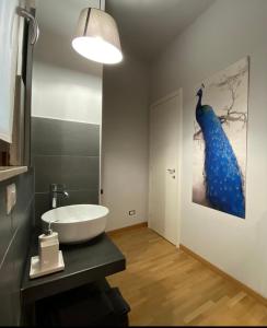 博爾戈馬內羅的住宿－Momi，浴室设有水槽,墙上挂着蓝色孔雀画