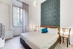 sypialnia z dużym łóżkiem i niebieską ścianą w obiekcie BDC - Termini Sun Apartment w Rzymie