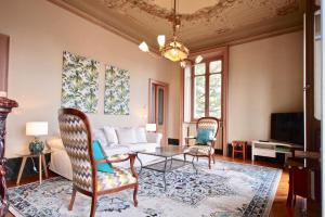 sala de estar con sofá, mesa y sillas en Villa Farinelli, en Cadegliano Viconago