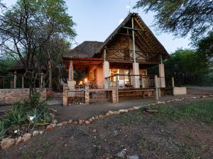 a large house with a thatched roof at Injabulo in Marloth Park