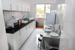 a kitchen with white cabinets and a counter with dishes at lisbon Home host in Lisbon