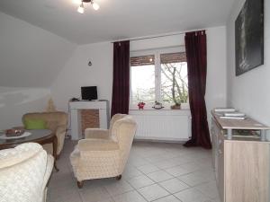 ein Wohnzimmer mit Stühlen, einem Tisch und einem Fenster in der Unterkunft Ferienwohnung "Landblick" in Lüdinghausen