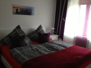 Un dormitorio con una cama con sábanas rojas y una ventana en City Marina, en Cuxhaven