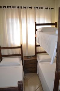 two bunk beds in a room with a window at Pousada Coqueiro Verde Minas Gerais in Mateus Leme