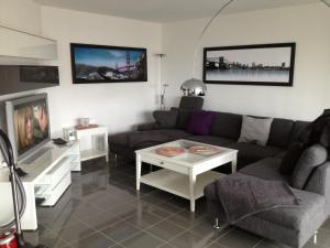sala de estar con sofá y TV en City Marina, en Cuxhaven
