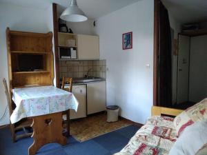 ein kleines Zimmer mit einem Tisch und einer Küche in der Unterkunft Studio proche funiculaire in Bourg-Saint-Maurice