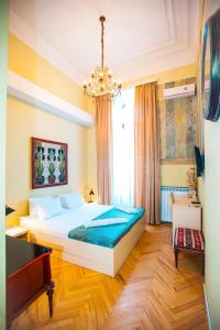 a bedroom with a large bed and a piano at Rustaveli Hotel in Tbilisi City