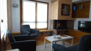 a living room with two chairs and a fireplace at Gaztanbide Apartamento rural in Ochagavía