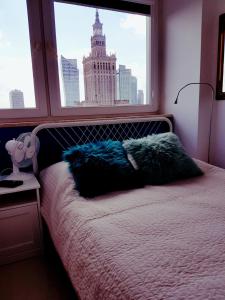 a bed with a window with a view of a building at Centre Apartamenty Warszawa in Warsaw