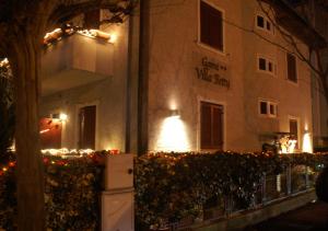 a building with a sign on the side of it at night at Garni Villa Betty in Merano