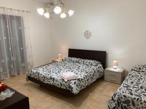 a bedroom with two beds and a table with lamps at Domus Grace in Catania
