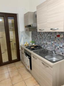 a kitchen with a sink and a stove top oven at Domus Grace in Catania